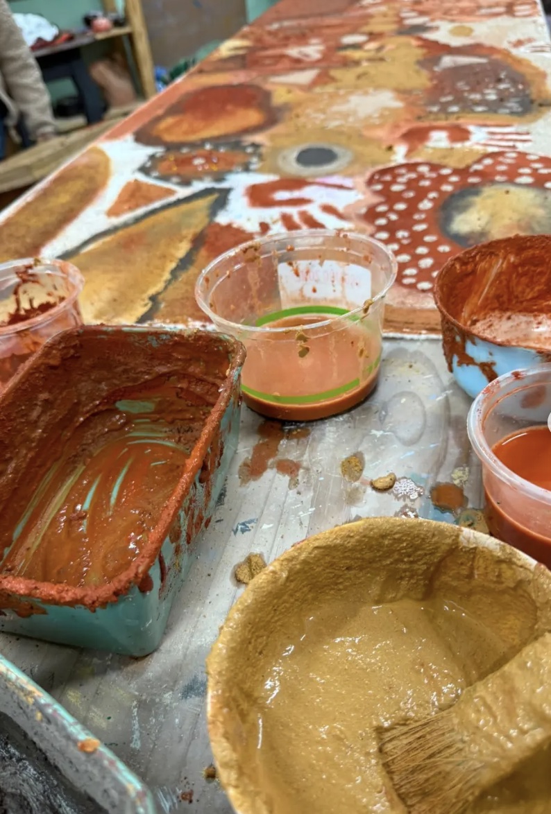 Bowls of earth pigments in ochre, rust, charcoal and yellow