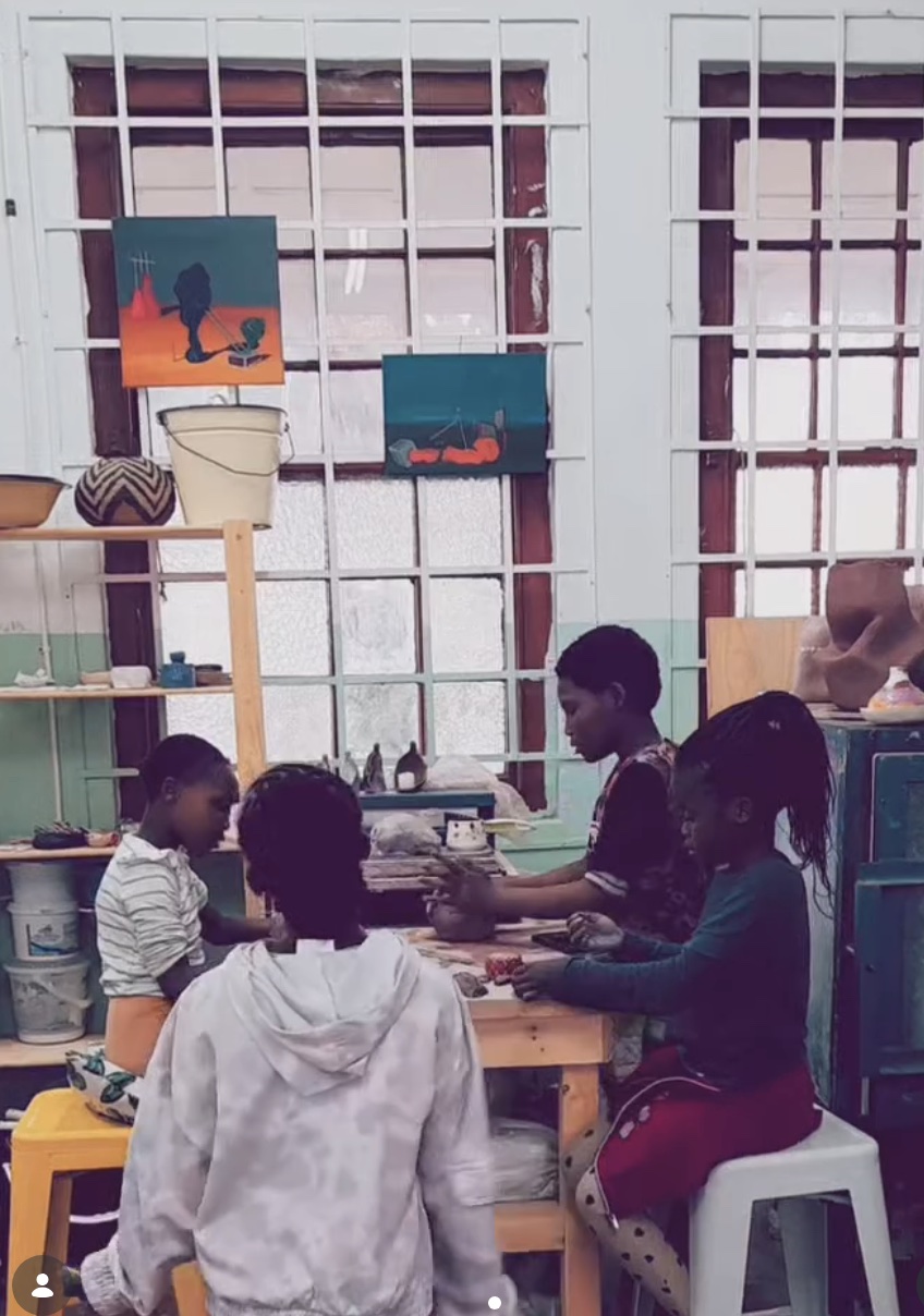 Children working together on artwork around a studio table